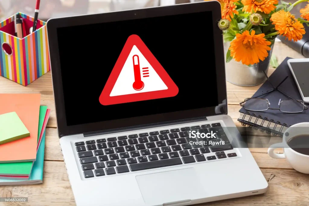 Laptop displaying a temperature warning symbol on the screen, indicating a potential overheating issue that may require attention.