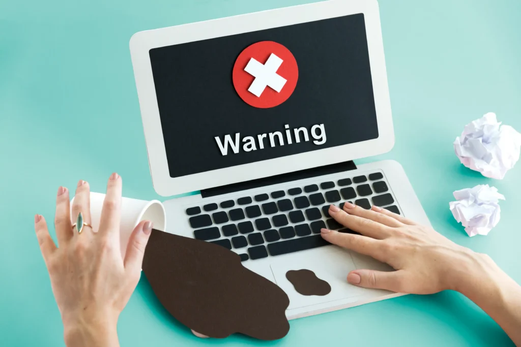 Laptop displaying a security warning symbol, representing malware or software security issues.