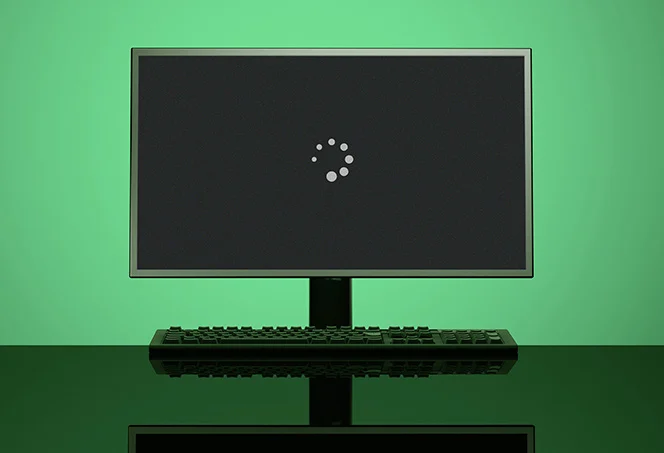 Windows startup black screen with loading animation on a desktop monitor