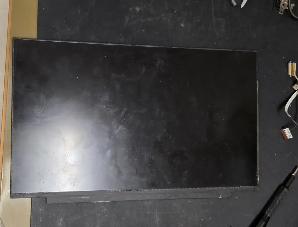 New replacement laptop LCD display panel resting flat on a technician workbench.