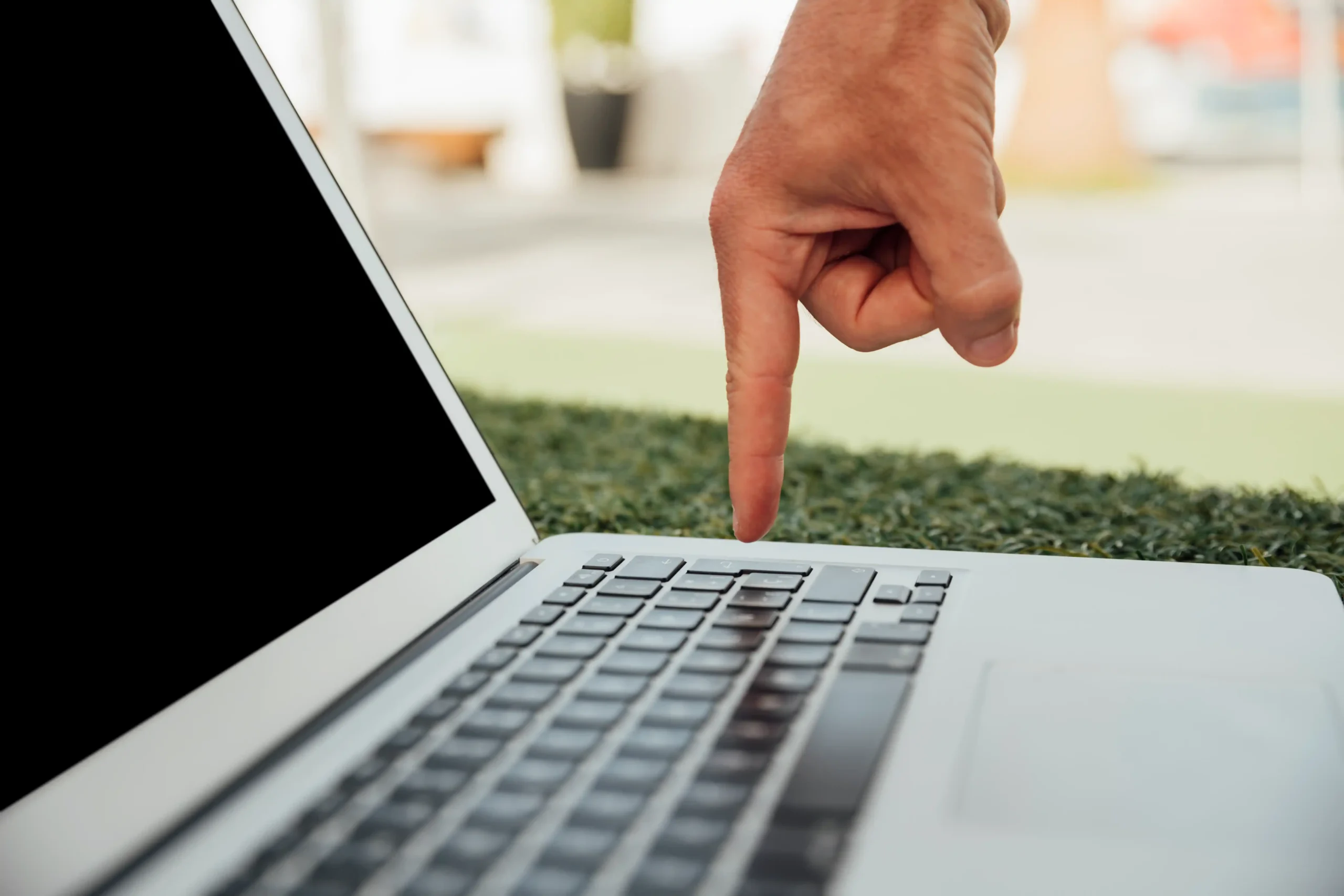 Person pressing a laptop keyboard while troubleshooting a black screen issue.