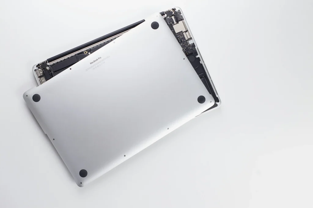 MacBook being carefully reassembled after battery replacement for final testing.